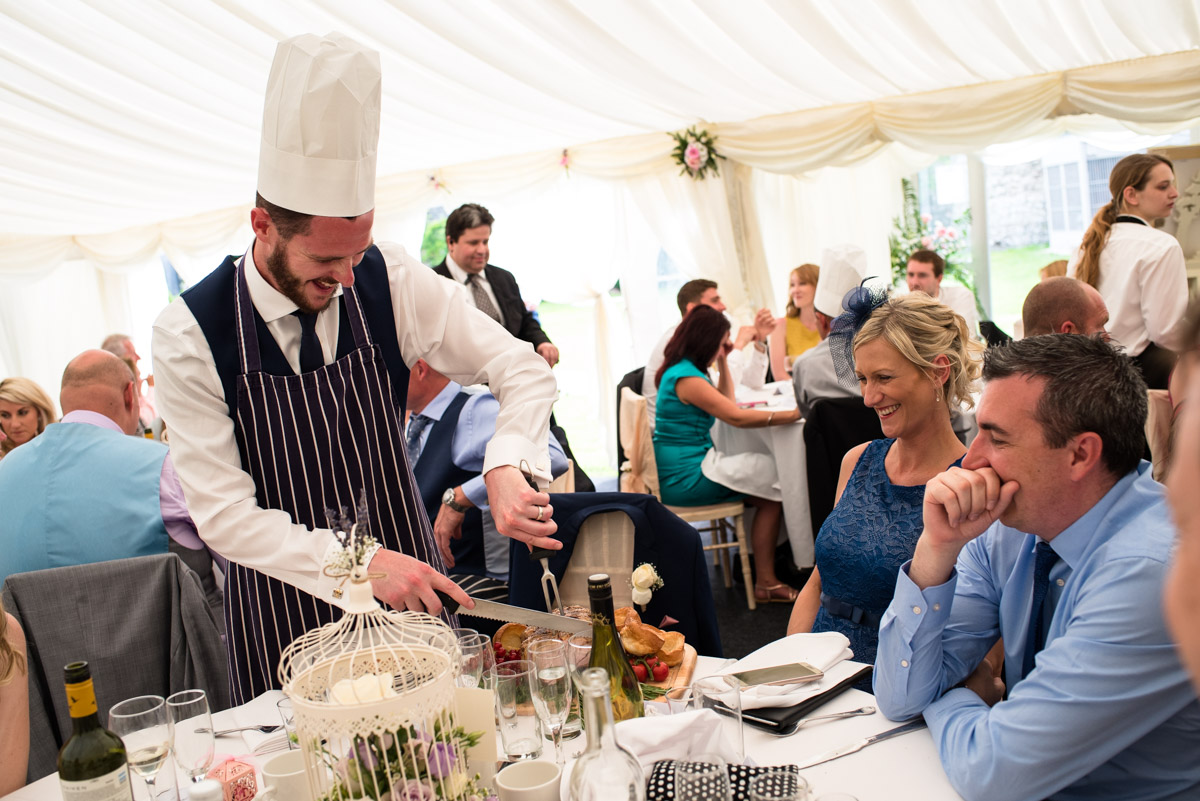 Guests at Paul and Lexys wedding are photographed during the wedding breakfast in the marquee in Kent