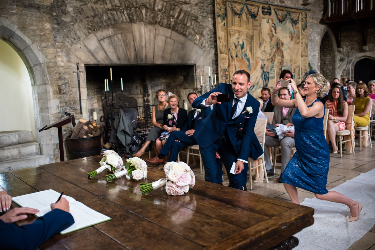 Wedding guests photograph Paul and Lexy signing the wedding register