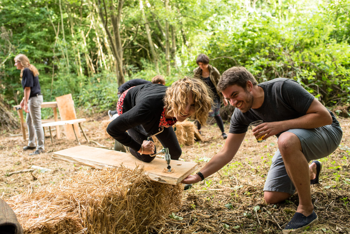 Photograph of wedding guests making tables at Seb and Brogans wedding celebration in Kent woods