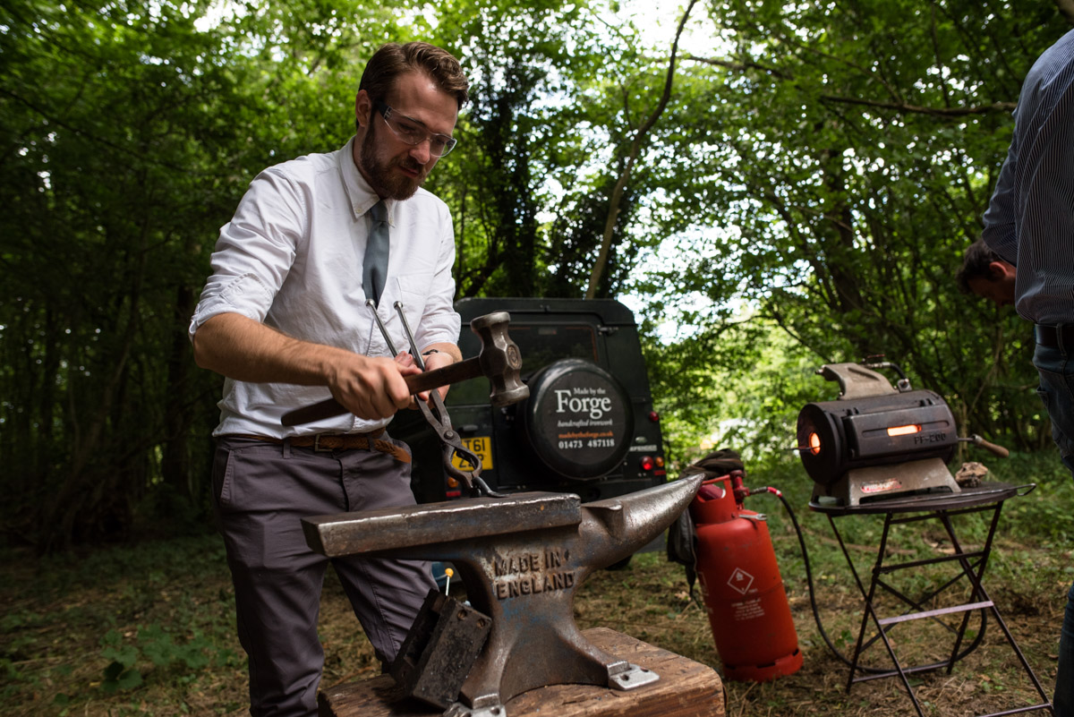 wedding guest is photographed trying ironmongery at sea and brogans wedding celebration in the woods