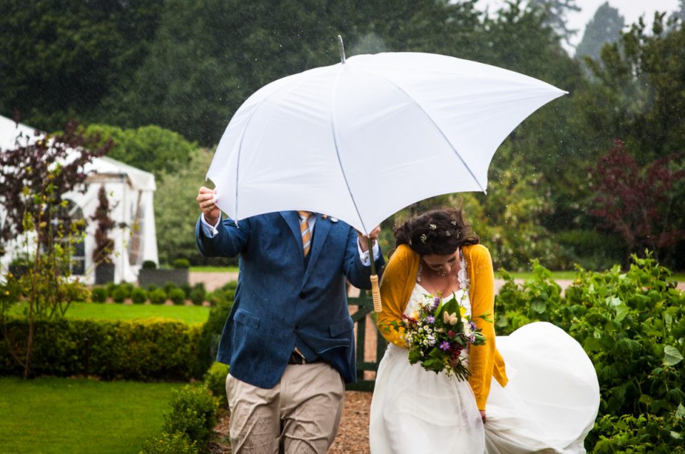 Photograph of rachel and Daniel on their wet wedding at the secret garden in kent