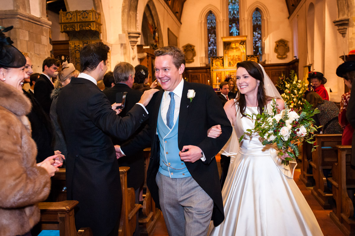 Classic wedding photograph of Marcus and Frances walking down the aisle after their wedding ceremony