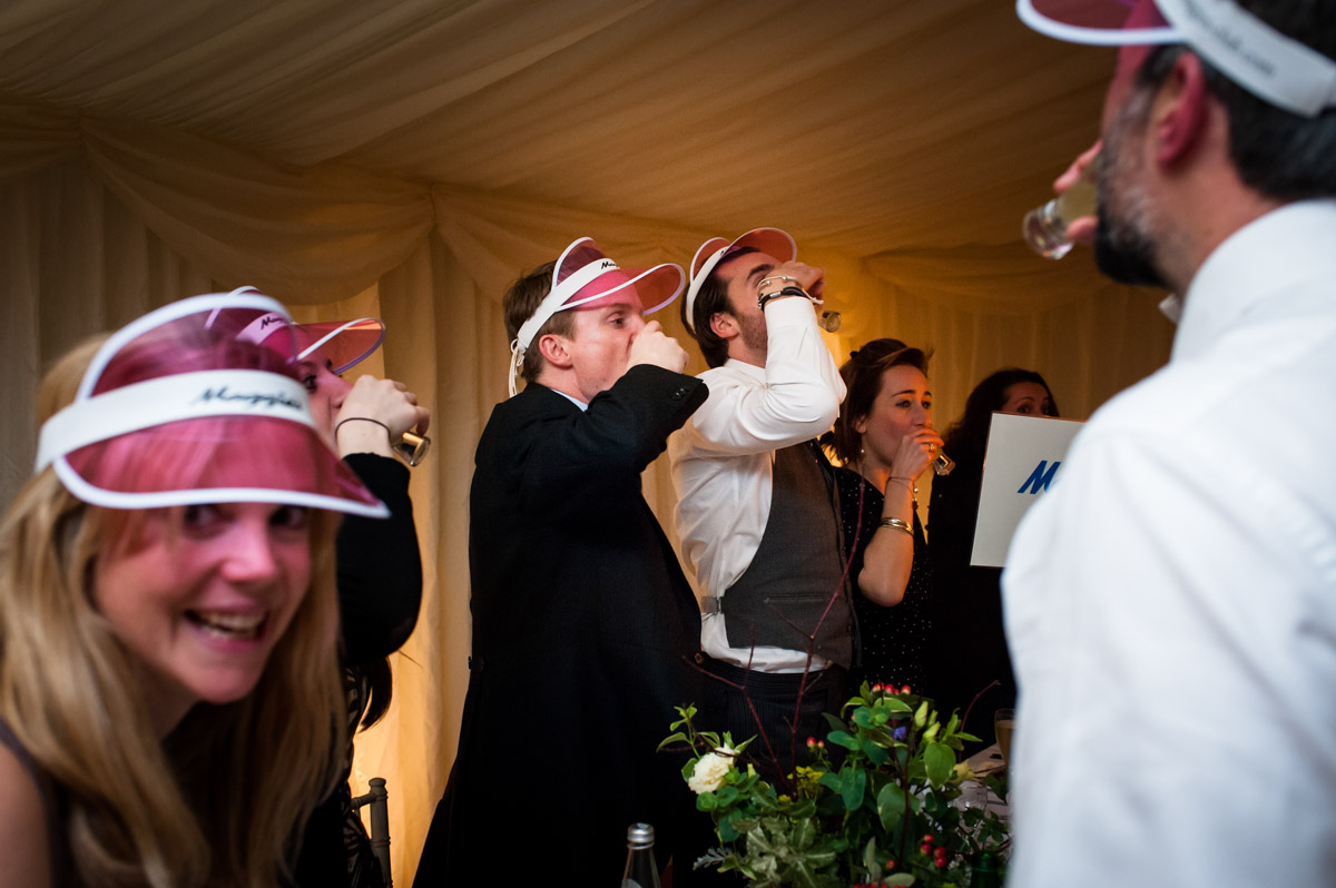Marcus and Frnaces wedding guests are photographed drinking shots at the wedding reception