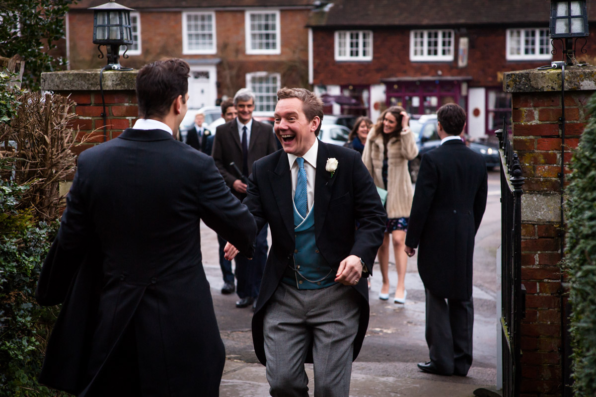 groom greets his friend outside the church on before his Kent church wedding