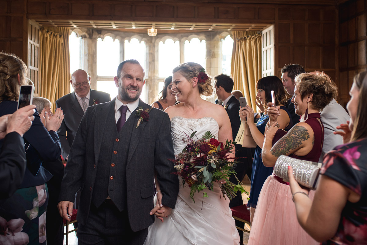 John and Lianne are photographed walking down the aisle after their wedding ceremony at Lympne Castle in kent