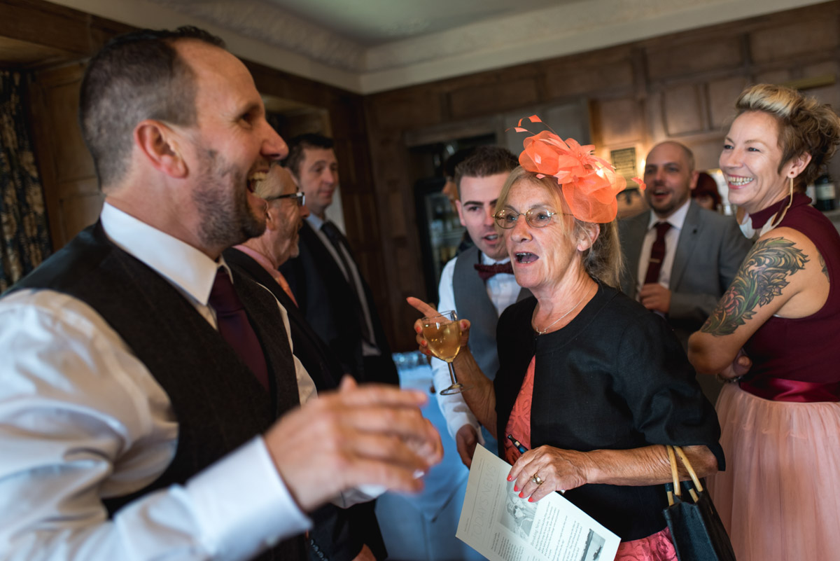 Photograph of wedding guests and John in the bar at Lympne Castle before the ceremony