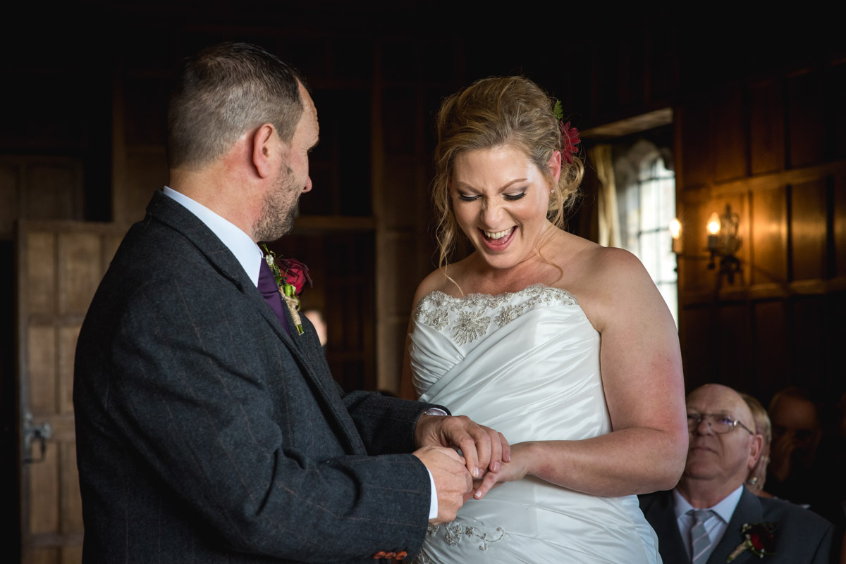 Photograph of John placing the ring on Liannes finger during their wedding at Lympne Castle in Kent