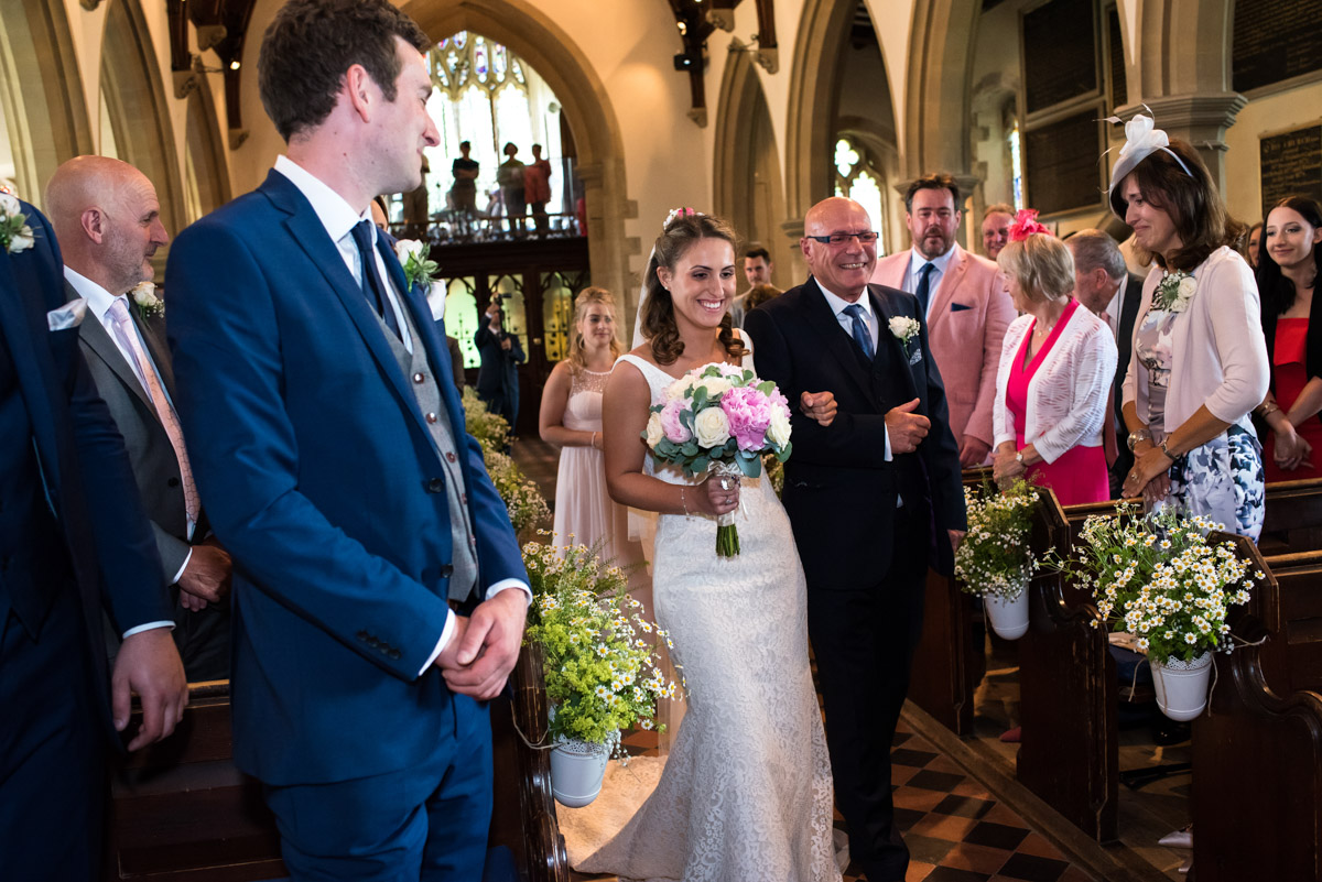 Photograph of Elie being walked down the church aisle by dad on her Kent wedding day