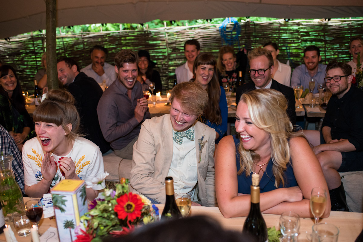 Seb and Brogan photographed laughing at wedding speeches at their Kent wedding party