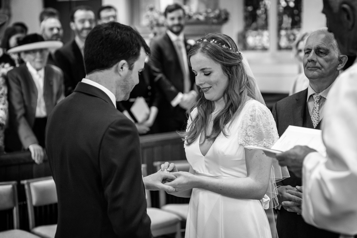 Photograph of Flora putting wedding ring on james during Kent wedding