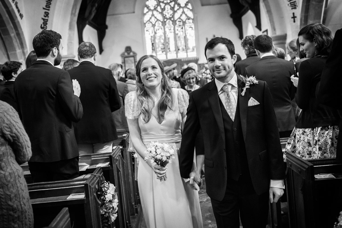 Flora and James photographed leaving church after their wedding ceremony