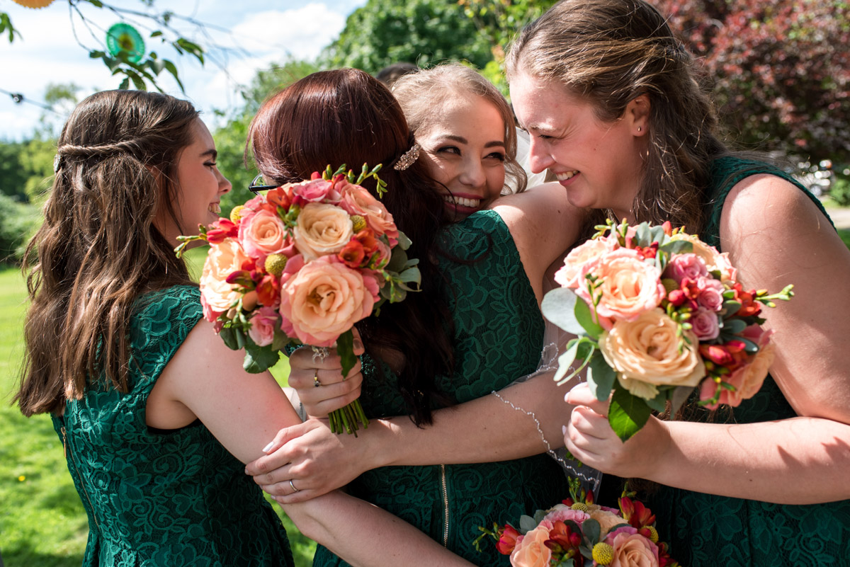 Beth hugs her bridesmaids after her wedding at Ratsbury Barn in Kent