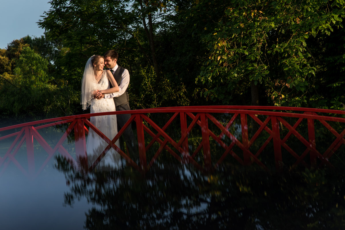 Beth and Tom on red foot bridge, Ratsbury Barn photography in Kent