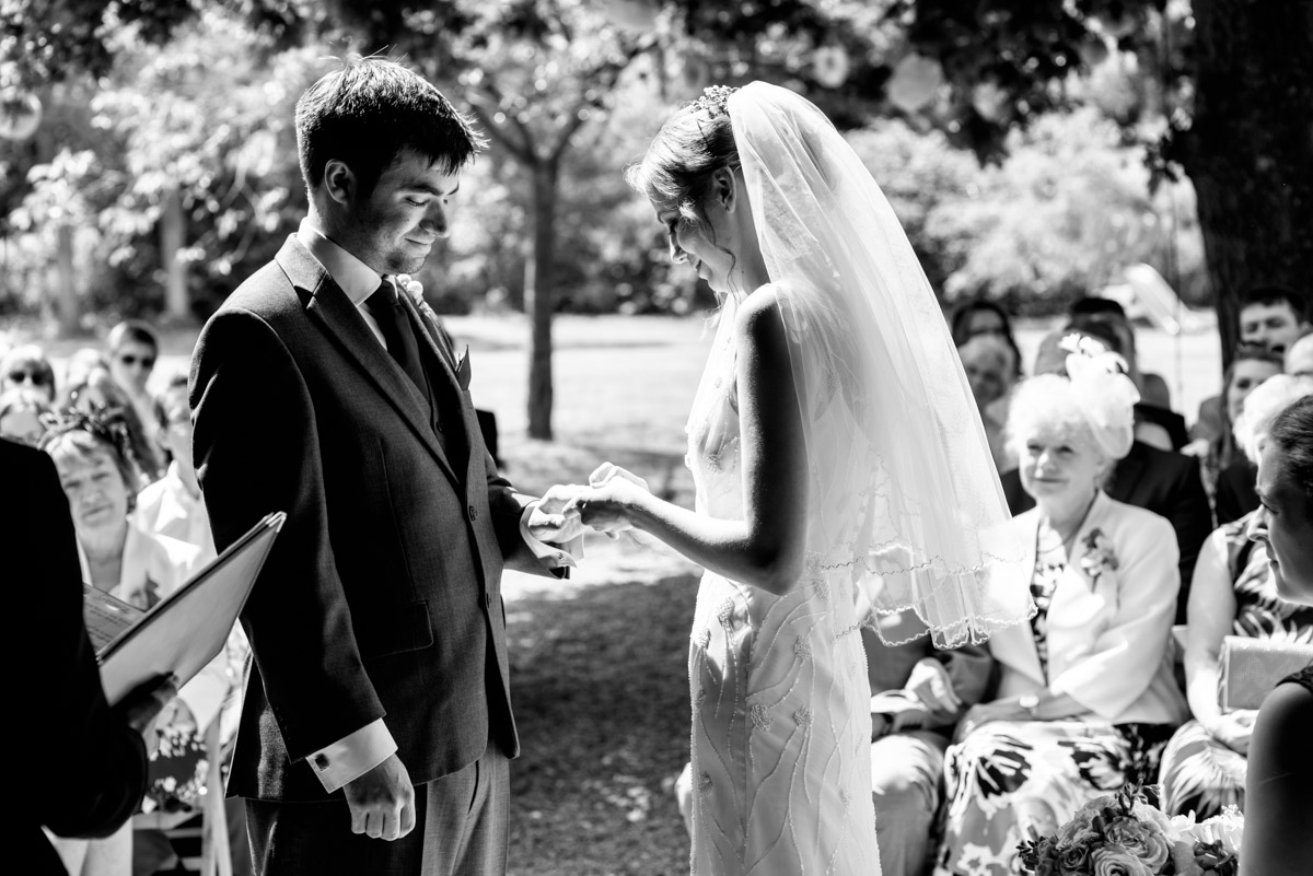 Beth places Toms wedding ring on his finger during their ceremony at Ratsbury barn in Kent