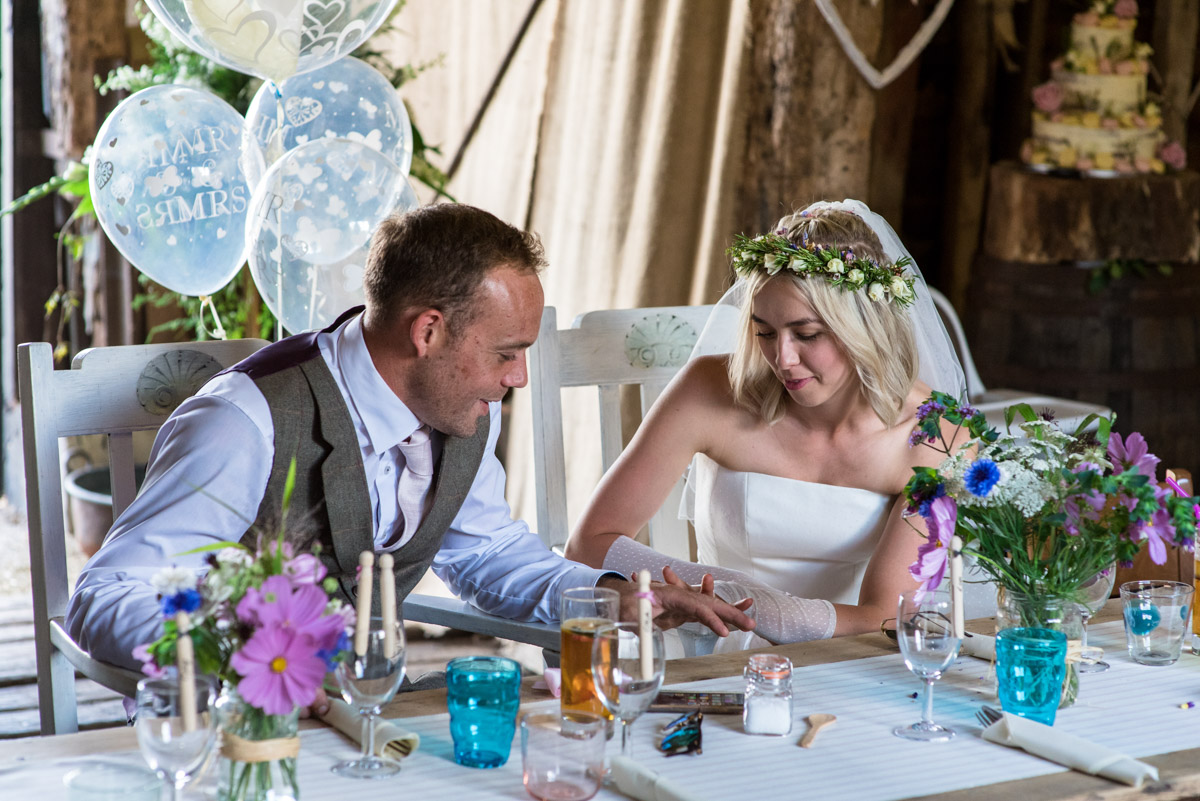 Photograph of Anne and Josh looking at their wedding rings