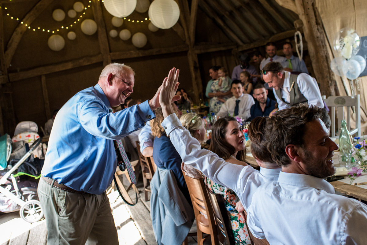 Wedding guests are photographed high fiveing