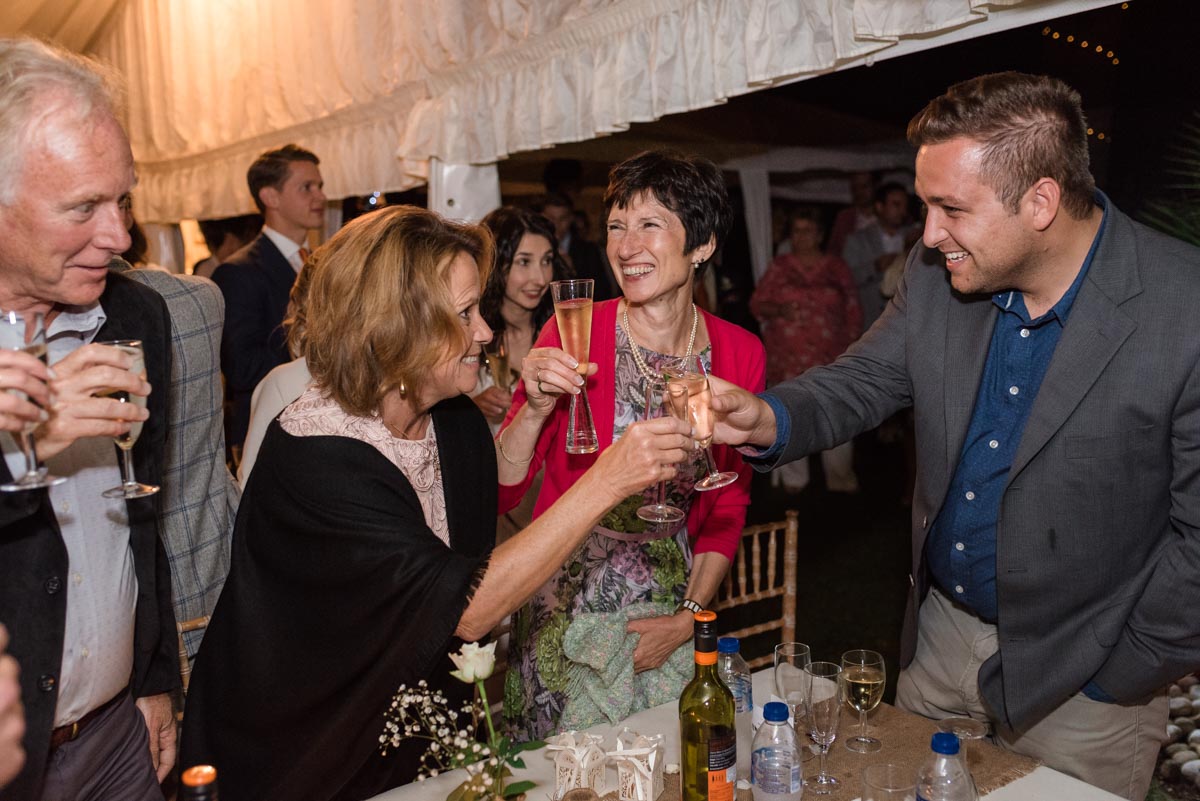 Photograph of wedding guests toasting Claire and Stefan