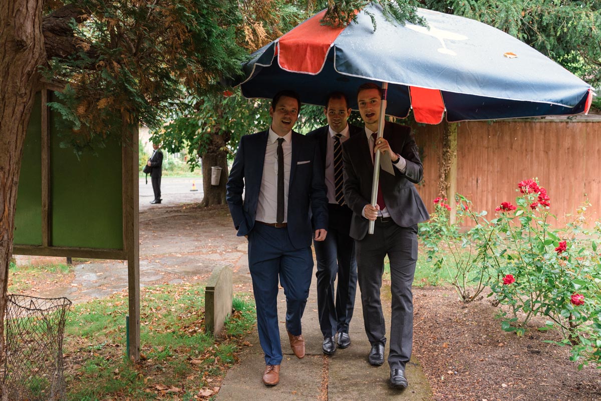 wedding guests and pub umbrella at james and Rebeccas church wedding in Kent