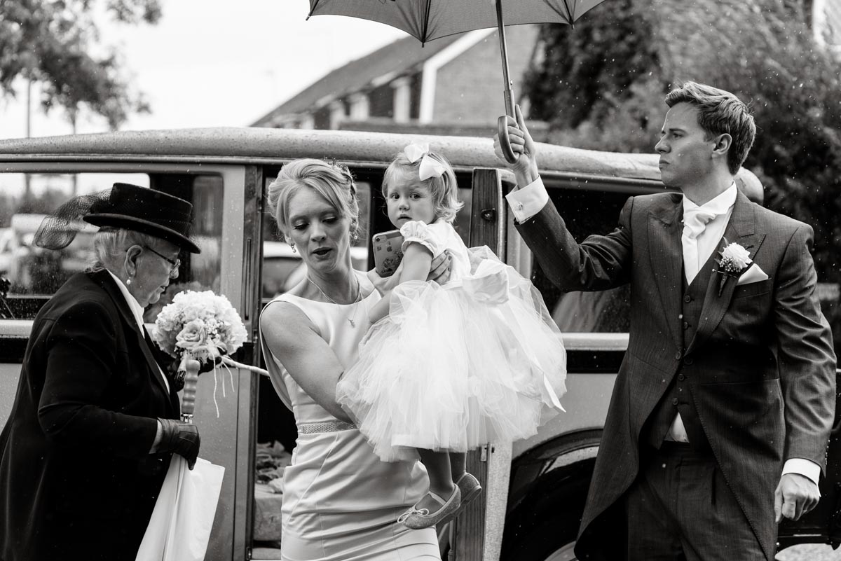 Bridesmaids and flower girl photographed outside church on Rebecca and James wedding day in Kent