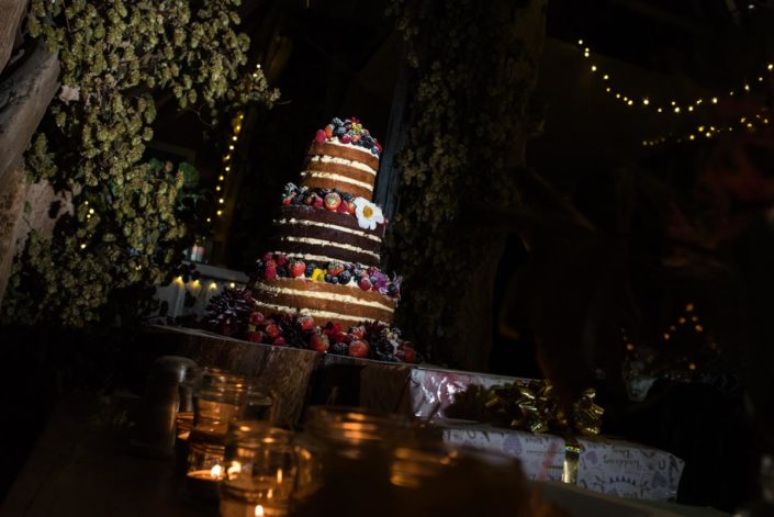 Photograph of naked wedding cake decorated with summer fruits
