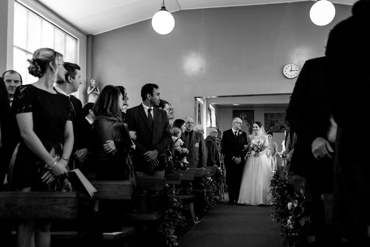 Katherine is walked down the aisle by her dad on her wedding day