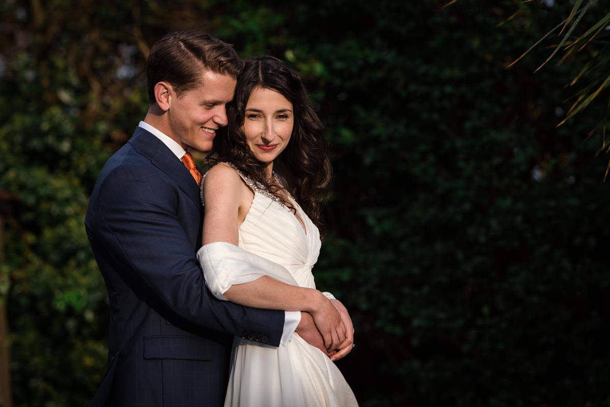 Photograph of wedding couple lit by evening sun