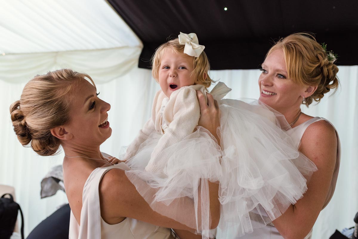 flower girl photographed pulling a face as her nappy is rearranged