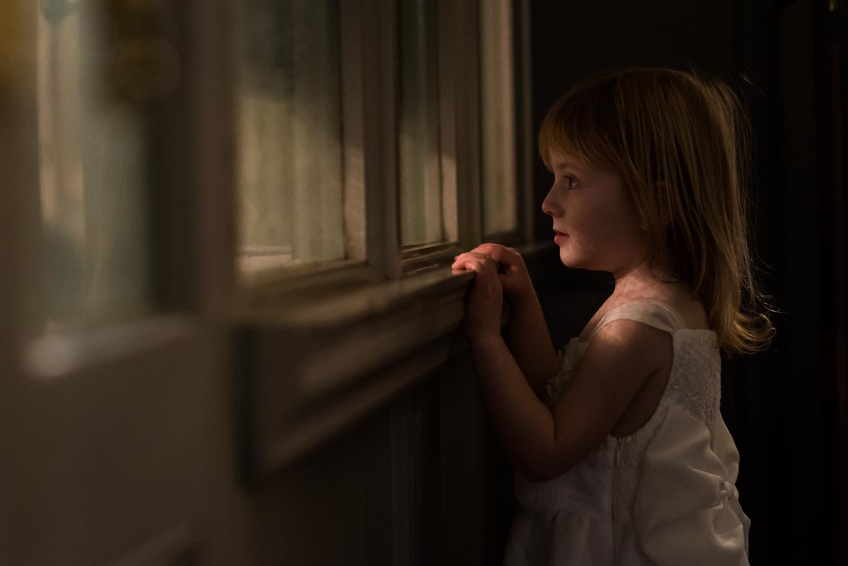 Chilston park hotel wedding photography, little bridesmaid peering through window