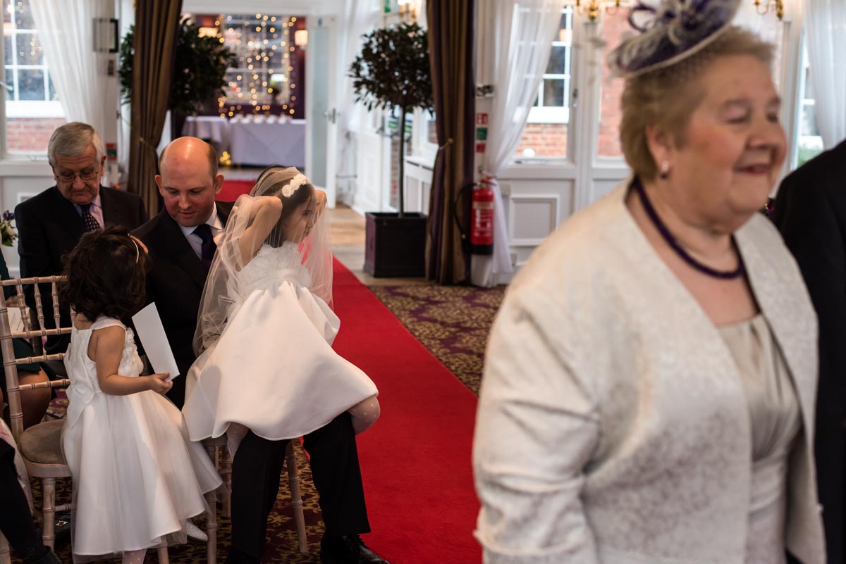 Bridesmaid plays with her dress during Jo and Grahams ceremony at Chilston Park