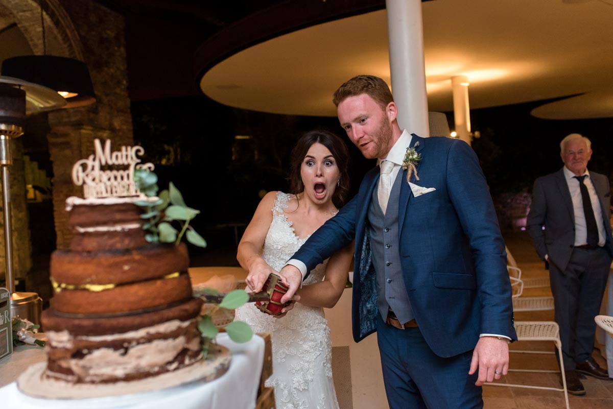 photograph of matt and rebecca cutting their wedding caje at castell d'emporda wedding venue in spain