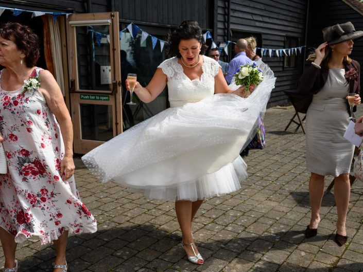 Nathalies wedding dress lifts in the wind during her Kent wedding reception