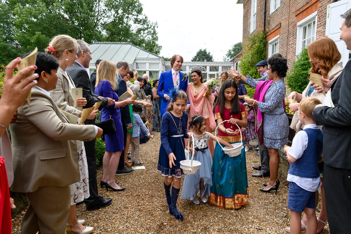 Doug & Vinita during confetti throw at Chilston Park wedding