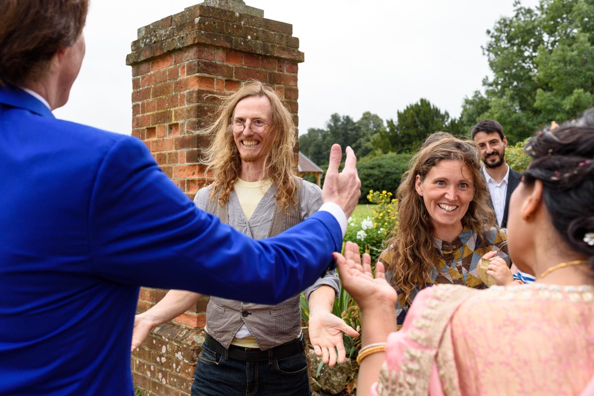 Vinita and Doug greet their friends at their wedding at Chilston park in Kent