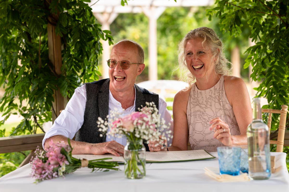 Phil and jenny signing register on their wedding day at the secret garden in Kent