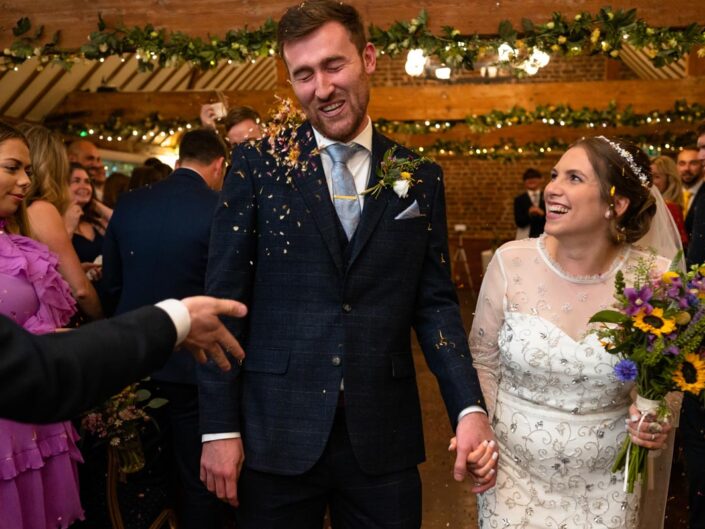 wedding photography best of 2021 photograph of julia and stephen having confetti thrown at them after wedding ceremony at the hop farm in kent