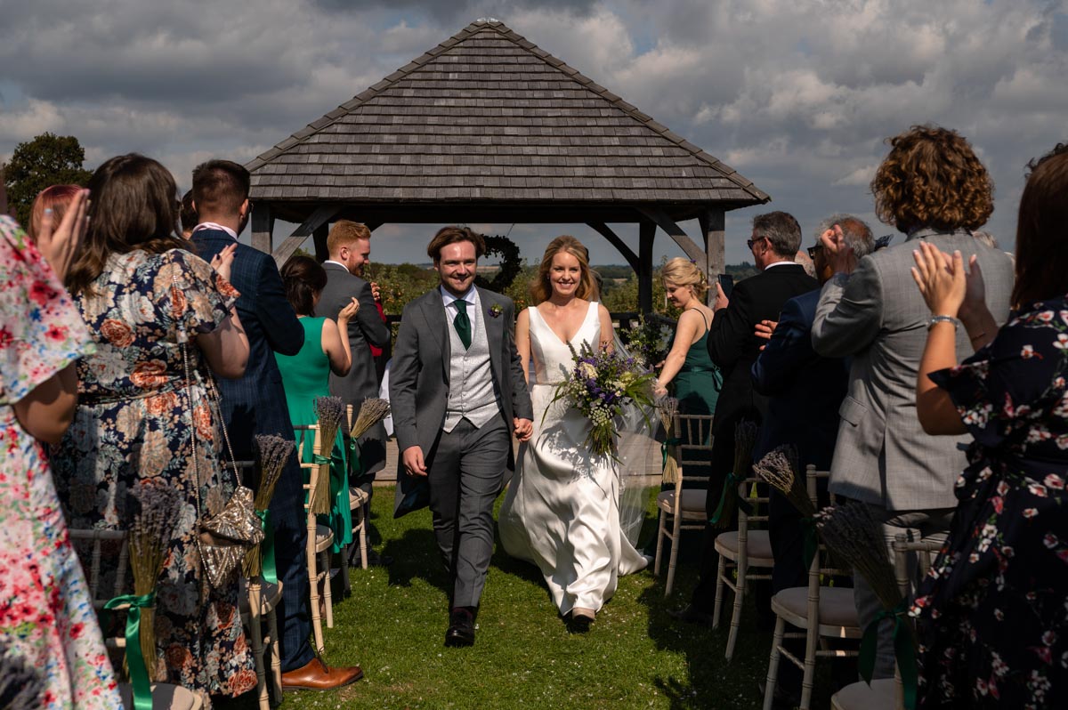 Newly weds Fiona and Chris after walk down the aisle after their ceremony in The Cherry Barn gazebo