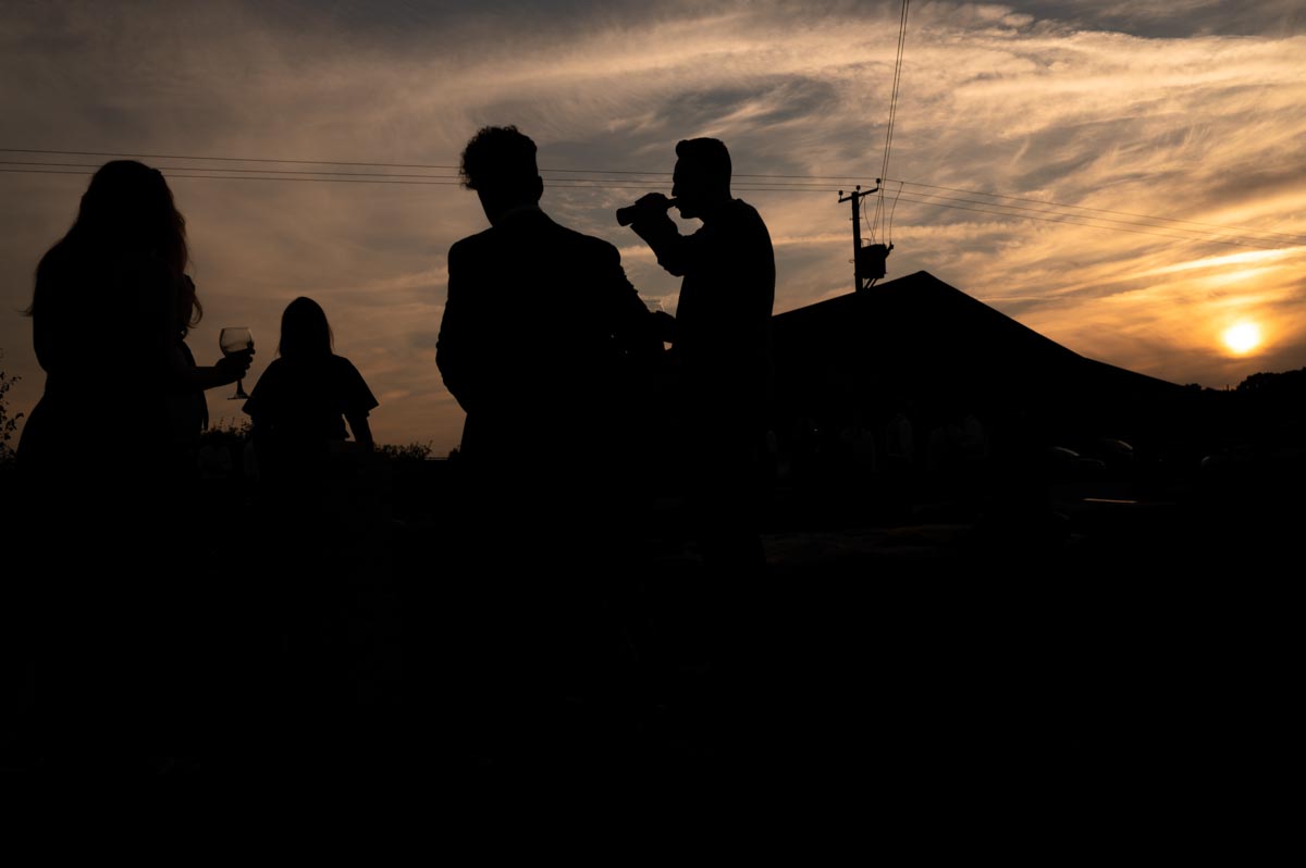 Silhouette photograph of guests at The Cherry Barn wedding of Fiona and Chris