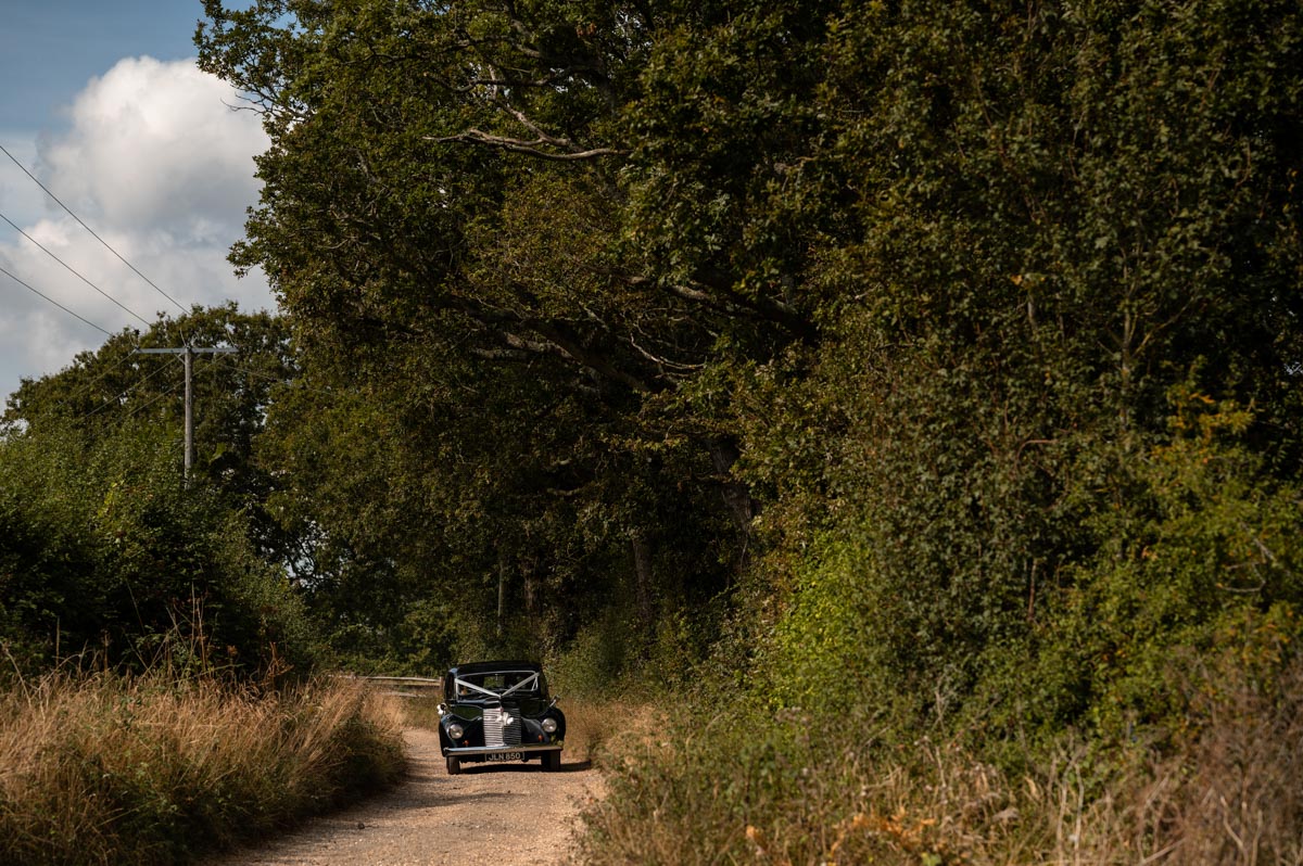 Fiona arrives in vintage car for her wedding at The Cherry Barn
