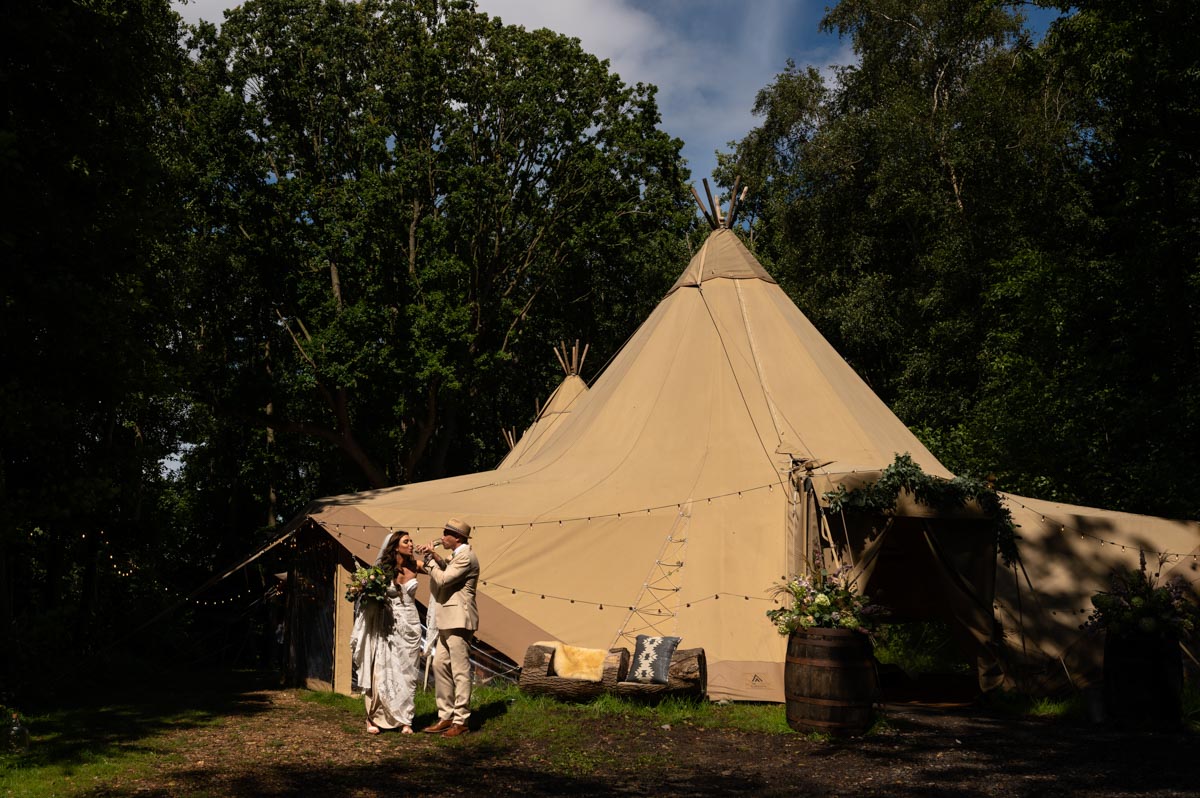 Couple outside Wilderness wedding venue tipi