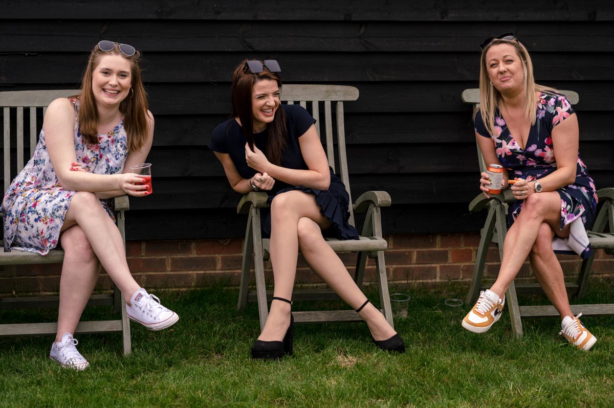 Friends laugh together after christening service in Kent