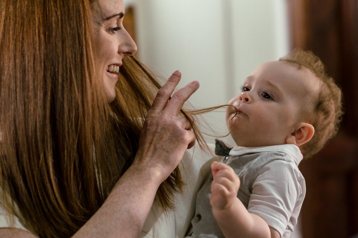 Ruperts christening at St Stephens church, Kent. Photograph of rupert chewing on mums hair