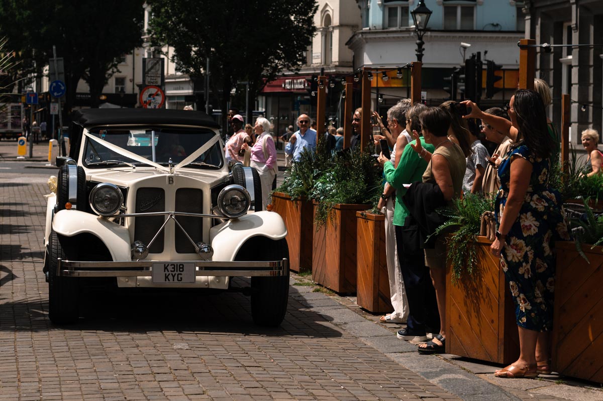 Guests at Donna and Sharon's Brighton Royal Pavillion wedding greeting the couple arriving in thir wedding car