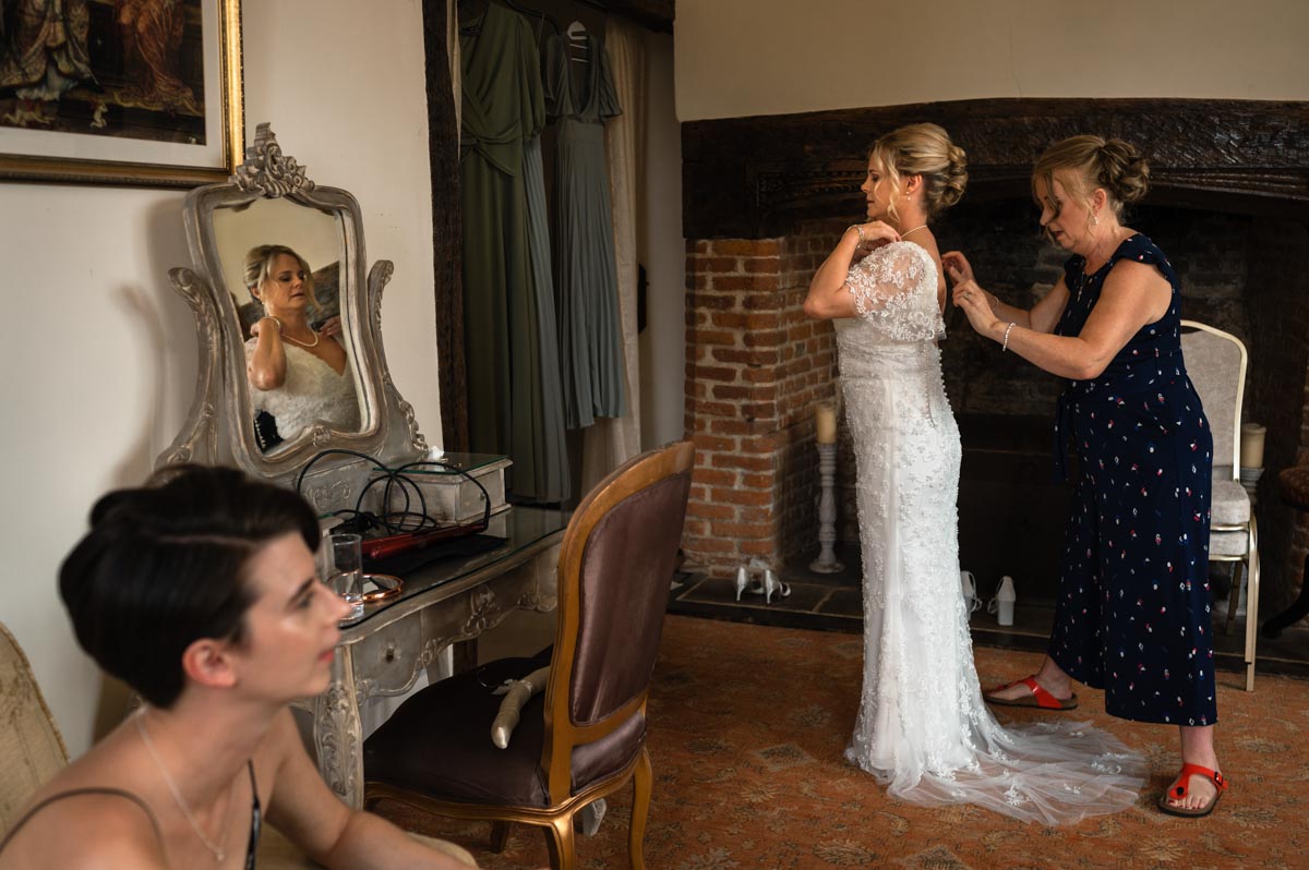 Westenhanger Hanger Castle wedding. Lara the bride puts on her wedding dress