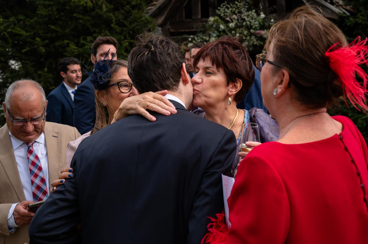 Groom gets a kiss at his wedding at Bilsington Priory in Kent