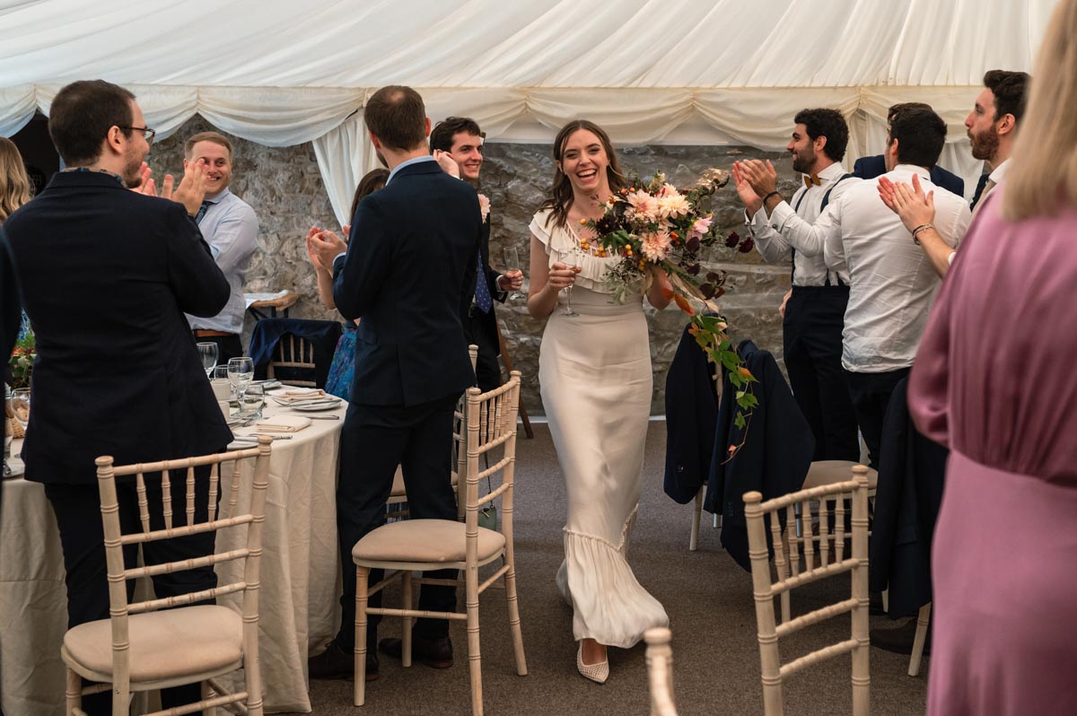 Poppy and Pablo photographed entering their wedding reception at Bilsington Priory.