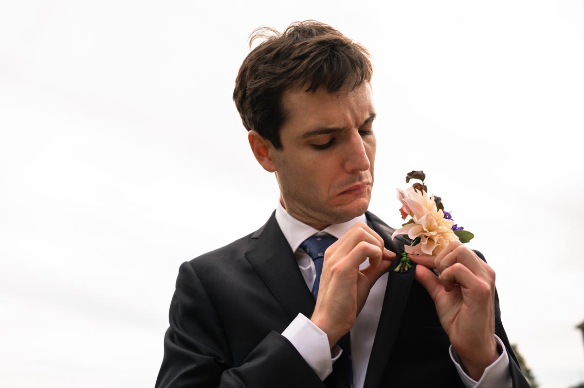 Bilsington Priory wedding photography. Pablo fixes his buttonhole