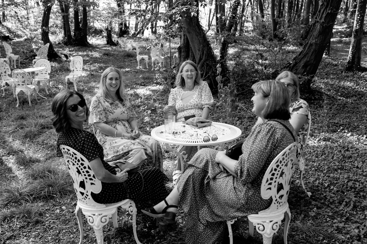 wedding guests enjoy cooling off in the shaded woodland at swallows oast