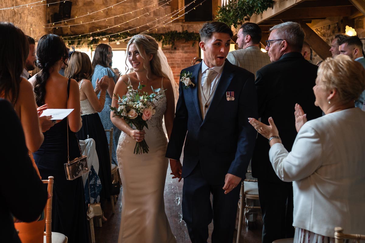 Swallows oast wedding photography. Sarah and James walk up the aisle after their ceremony.