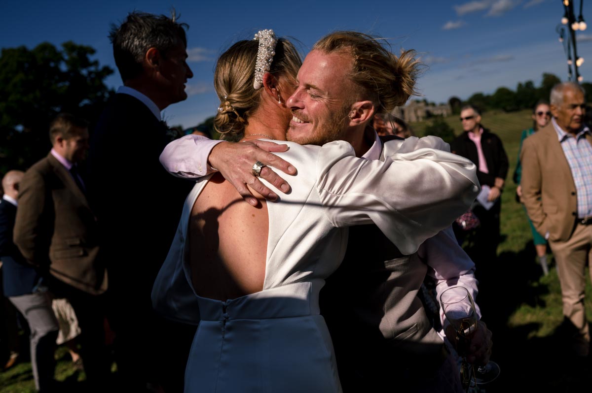 Natural wedding photography. Sarah hugs guest