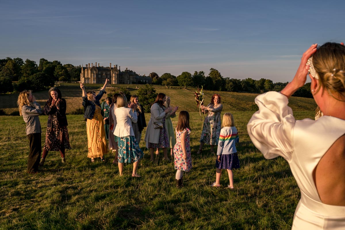 Natural wedding photography. Guests celebrate after the bouquet toss
